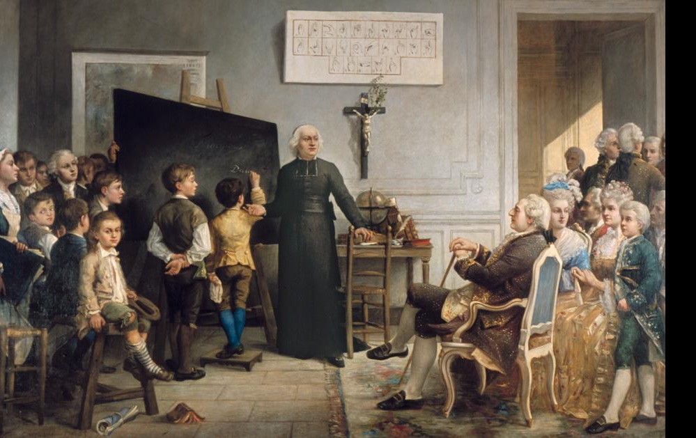 Charles-Michel de l'Épée ensinando seus alunos na presença do rei francês Luís XVI (obra de Gonzague Privat, 1875) Padre ensinando crianças em uma sala, com um alfabeto manual na parede e uma plateia observando
